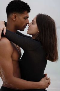 Side view of young couple  hugging at beach