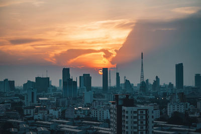 Modern buildings against sky during sunset