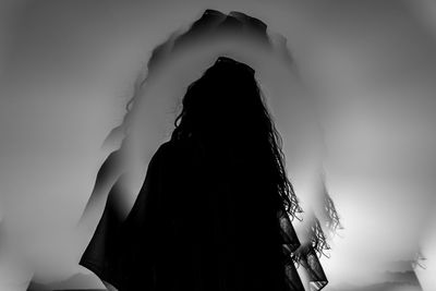 Rear view of woman standing against wall