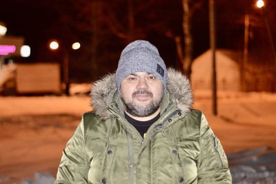 Portrait of man wearing hat during winter at night