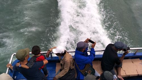 High angle view of people standing in sea