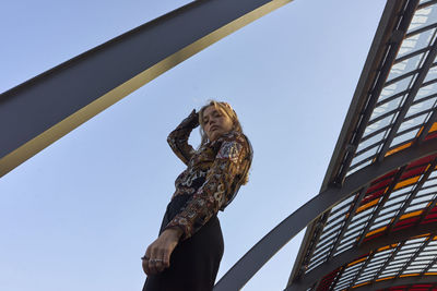 Low angle view of woman against clear sky