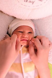 Portrait of cute baby girl lying in hat