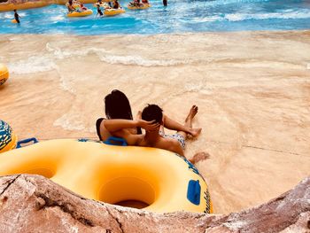 High angle view of people sitting by inflatable ring in water park