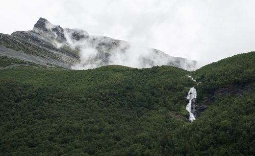 Scenic view of waterfall against sky