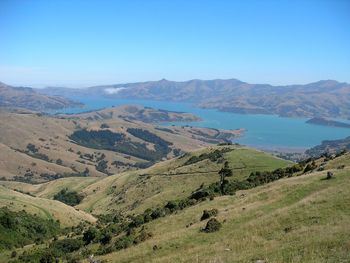 Scenic view of landscape and mountains against clear blue sky