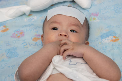 Portrait of cute baby boy on bed