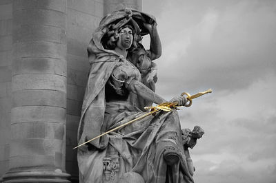 Low angle view of angel statue against sky