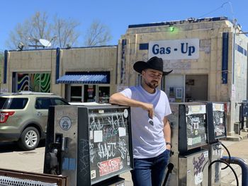 Side view of man standing at gass station