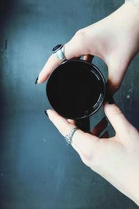 Cropped image of woman hand holding black coffee in cup