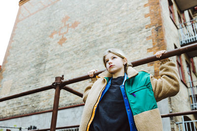 Contemplative girl looking away while hanging on railing