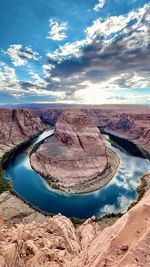 Rock formations on landscape against cloudy sky