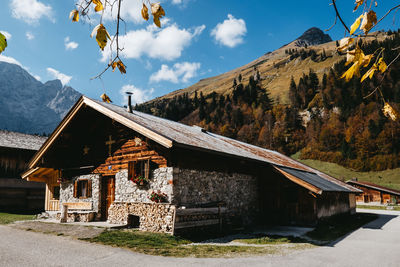 House amidst trees and buildings against sky