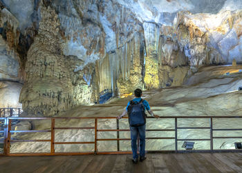 Rear view of man standing in cave