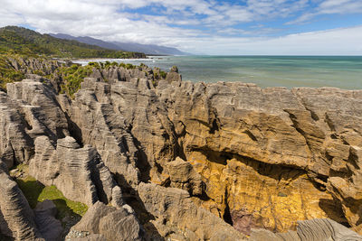 Scenic view of rocks in sea against sky