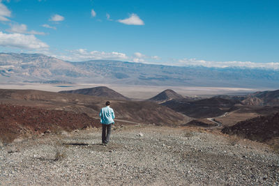 Man standing on arid landscape against sky