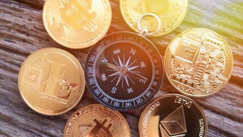 Directly above shot of navigational compass and coins on wooden table