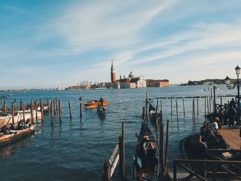 Boats in sea against buildings in city