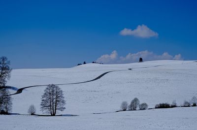 Scenic view of snow covered landscape against blue sky