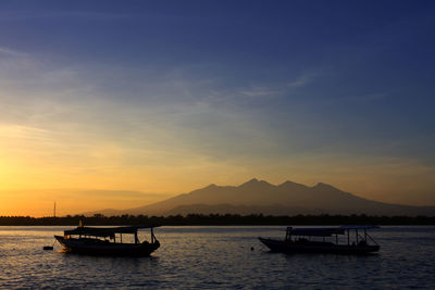 Boat in lake against sky during sunset