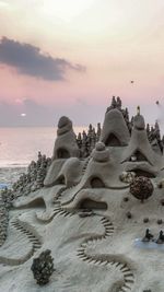 Close-up of beach against sky during sunset