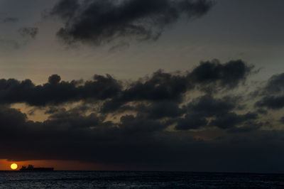 Scenic view of sea against dramatic sky during sunset