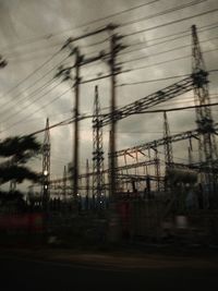 Silhouette electricity pylon against sky at dusk