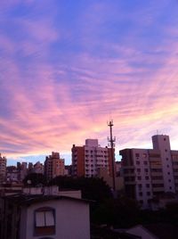 Buildings against cloudy sky at sunset