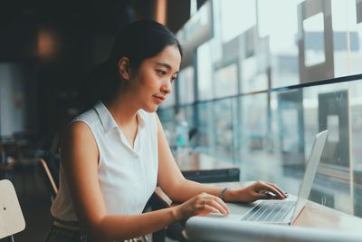 Young woman using mobile phone in office