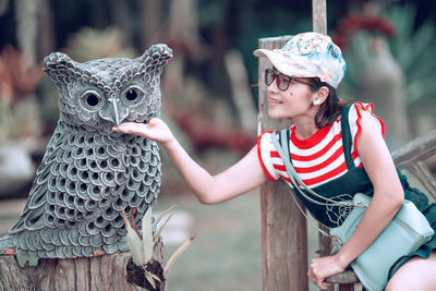 Smiling woman touching owl statue