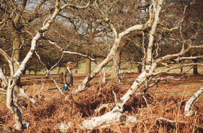 Full length of woman standing on tree trunk