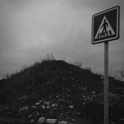 Low angle view of road sign against sky