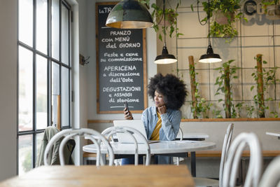 Woman sitting on table in restaurant