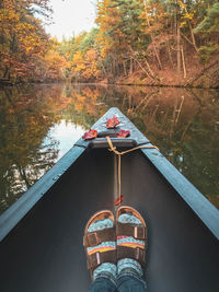 Reflection of person on boat in lake at forest