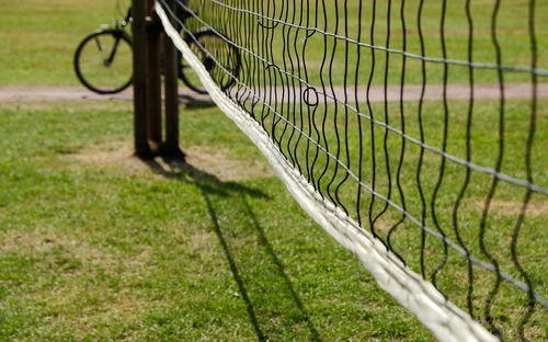 Close-up of barbed wire fence on field
