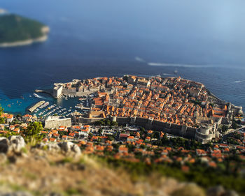 High angle view of townscape by sea against sky