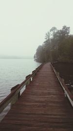 Wooden pier over sea against sky