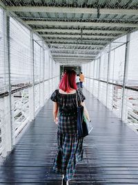 Rear view of woman walking on corridor