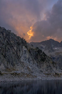 Scenic view of lake and mountains against sky during sunset