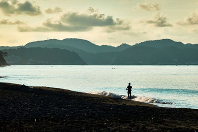 Man standing on beach against sky in the morning