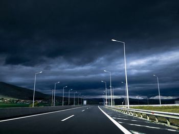 Empty road leading towards dramatic sky