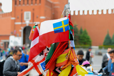 Close-up of flags and people in front of building