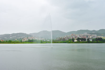 Scenic view of lake by buildings against sky