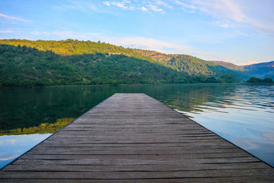 Scenic view of lake by mountains against sky