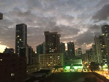 Illuminated buildings in city against sky at night