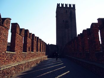 Man walking on road leading towards castelvecchio