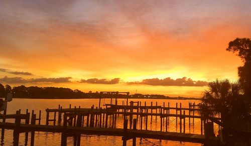 Pier over lake against dramatic sky