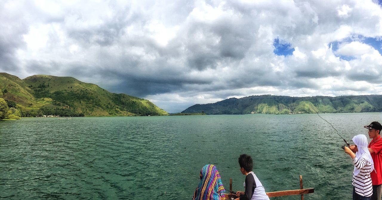 water, sky, cloud - sky, lifestyles, leisure activity, cloudy, mountain, scenics, cloud, lake, beauty in nature, tranquil scene, nature, tranquility, men, sea, nautical vessel, vacations