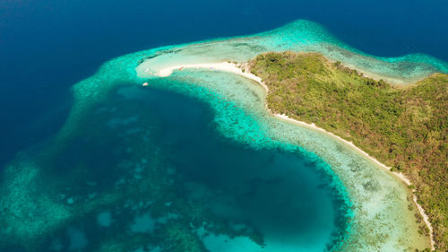 Tropical beach on island ditaytayan. tropical island with white sand bar, palm trees and green hills