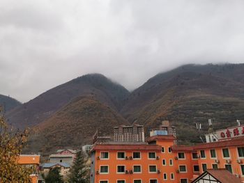 Town by mountains against sky